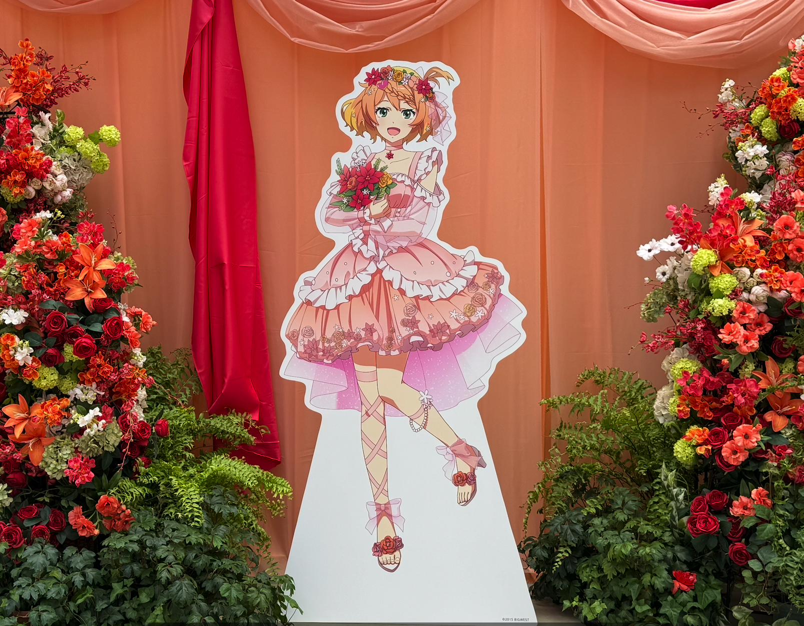 花に囲まれたフレイア・ヴィオンの等身大パネル