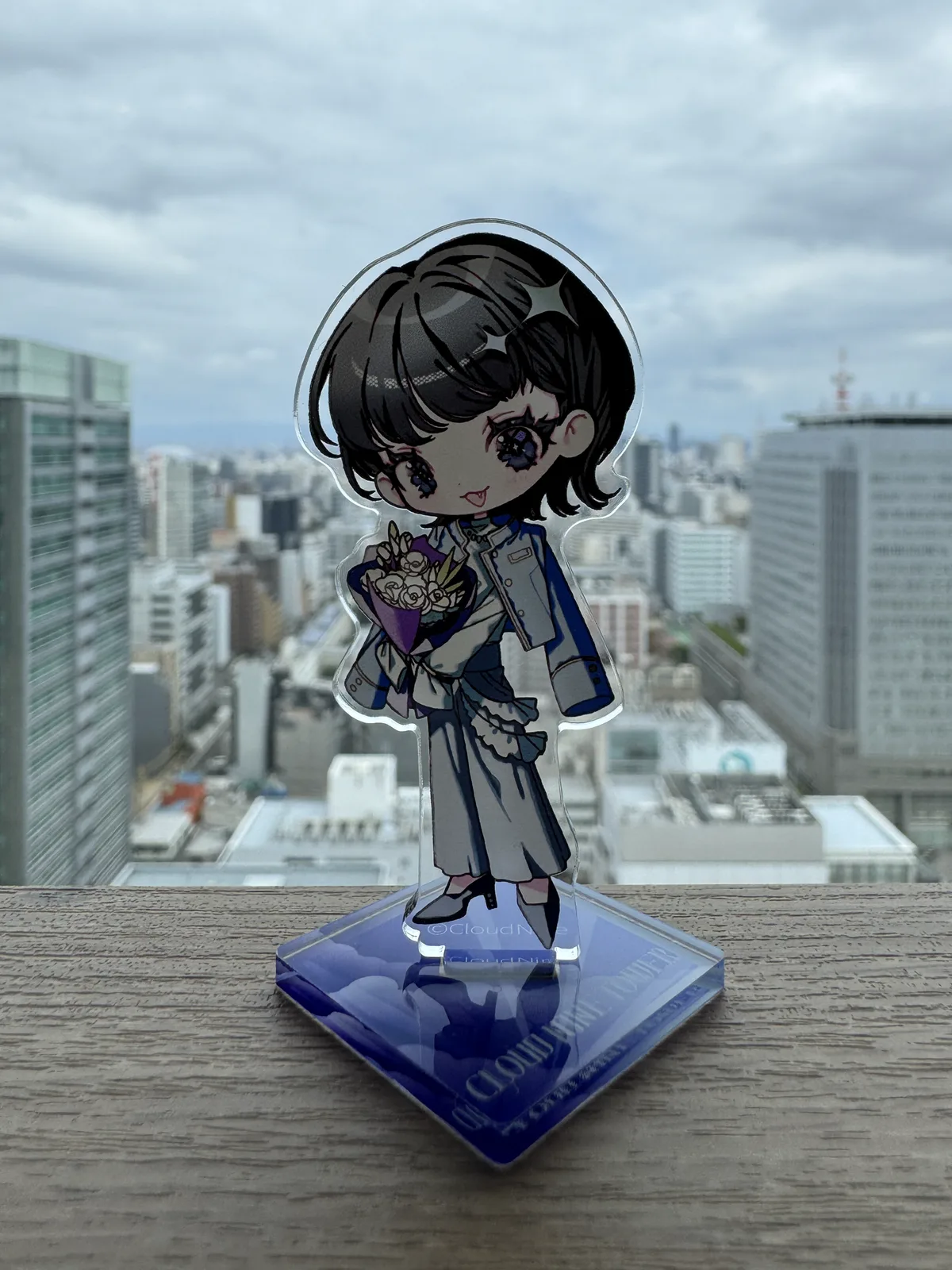 名古屋の街並みを背景にした鈴木みのりの描き下ろしアクリルスタンド